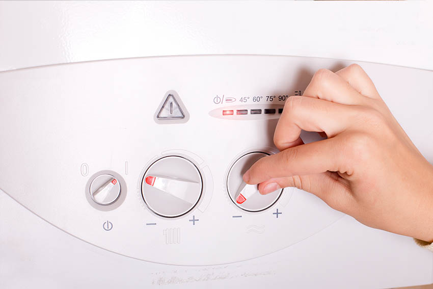Sanitär Express – Frau bedient das Thermostat einer Gastherme
